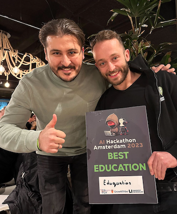 Two guys holding an award plaquette in their hands.