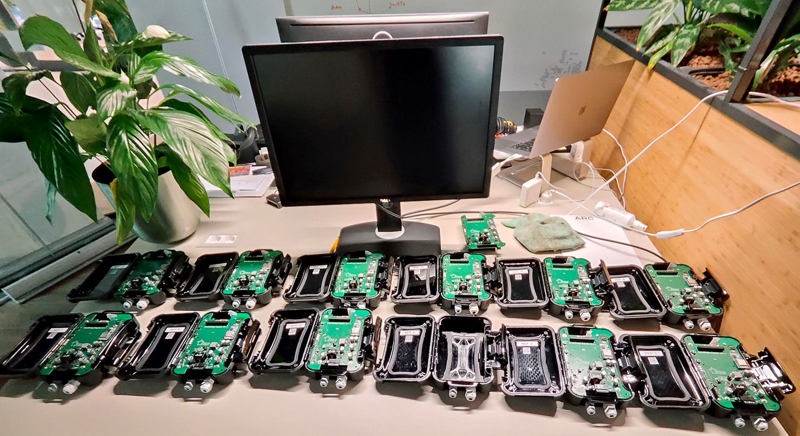 Desk with a monitor and several little black boxes with control circuitry. 